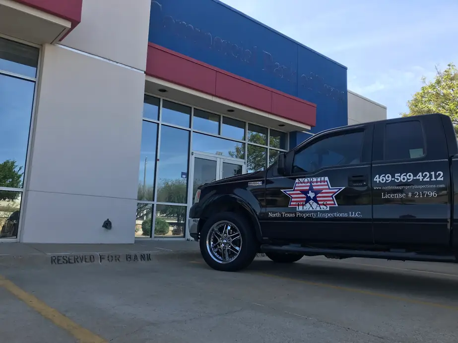 North Texas Property Inspections truck with its door decal, parked outside a commercial bank building